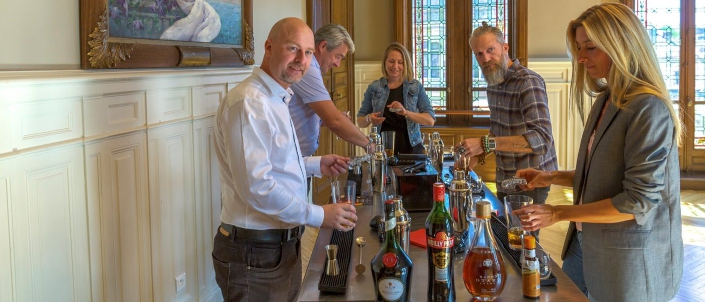 5 people are enjoying a cocktail initiation with Bénédictine liqueur and all the mixological equipment